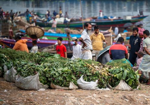 Fruit and vegetable traders on the banks of the Buriganga River in sadarghat region of Dhaka, capital city of Bangladesh. Workers and traders are clearly visible.