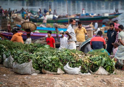 Fruit and vegetable traders on the banks of the Buriganga River in sadarghat region of Dhaka, capital city of Bangladesh. Workers and traders are clearly visible.